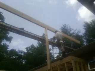 Carpenter setting a ridge beam over a new addition frame — Ice Dam Removal by Roofing Brothers in Mahwah