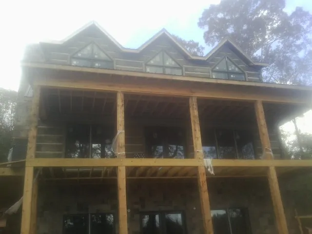 Dormers and porch framing on a large log home under construction — Roof Coating work by our crew in Mahwah